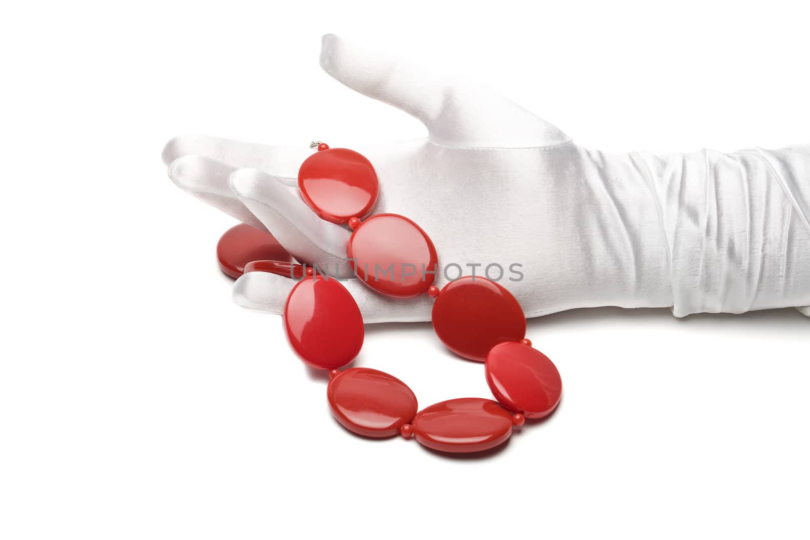 woman's hand in a white glove holding a red necklace