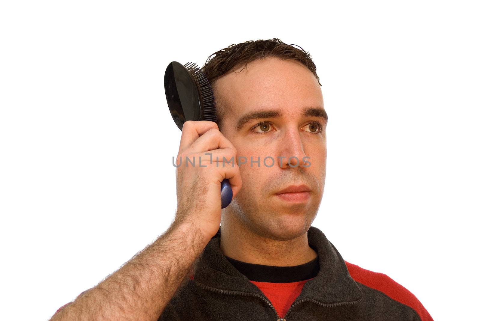 Young male brushing his hair, isolated against a white background