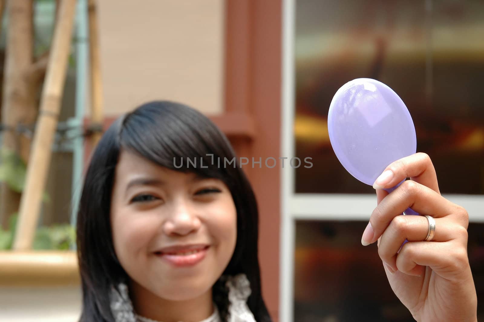 young lady holding a make up mirror