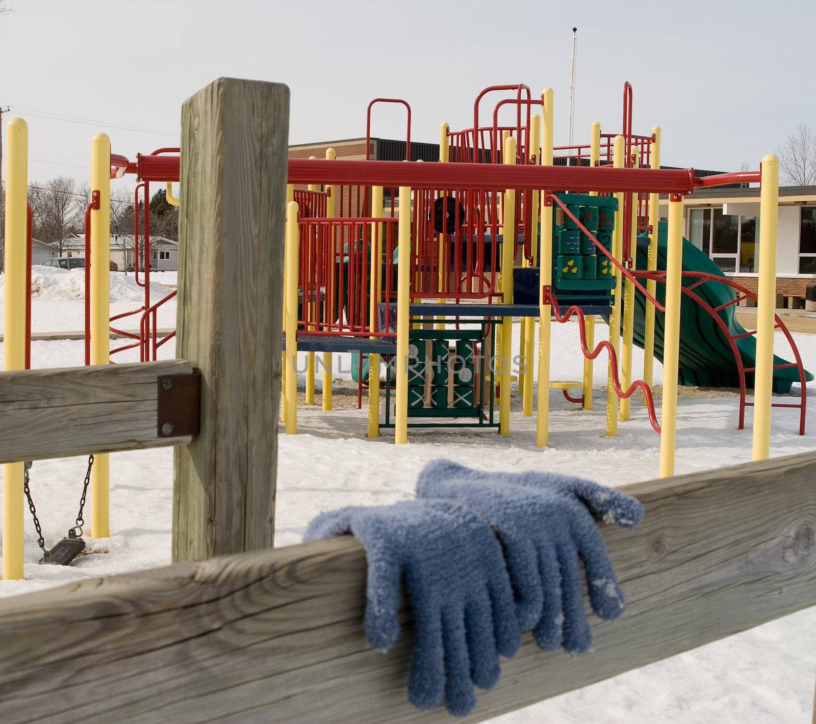 A pair of children's gloves hanging in the sun to dry