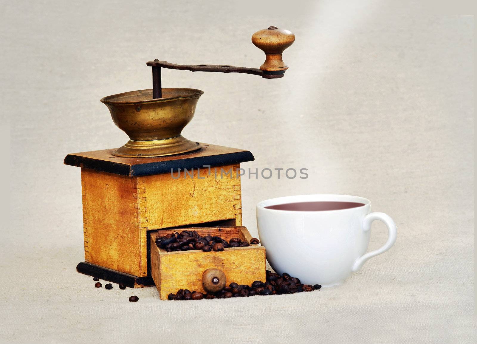 Antique coffee grinder with coffee beans an cup of hot black coffee 