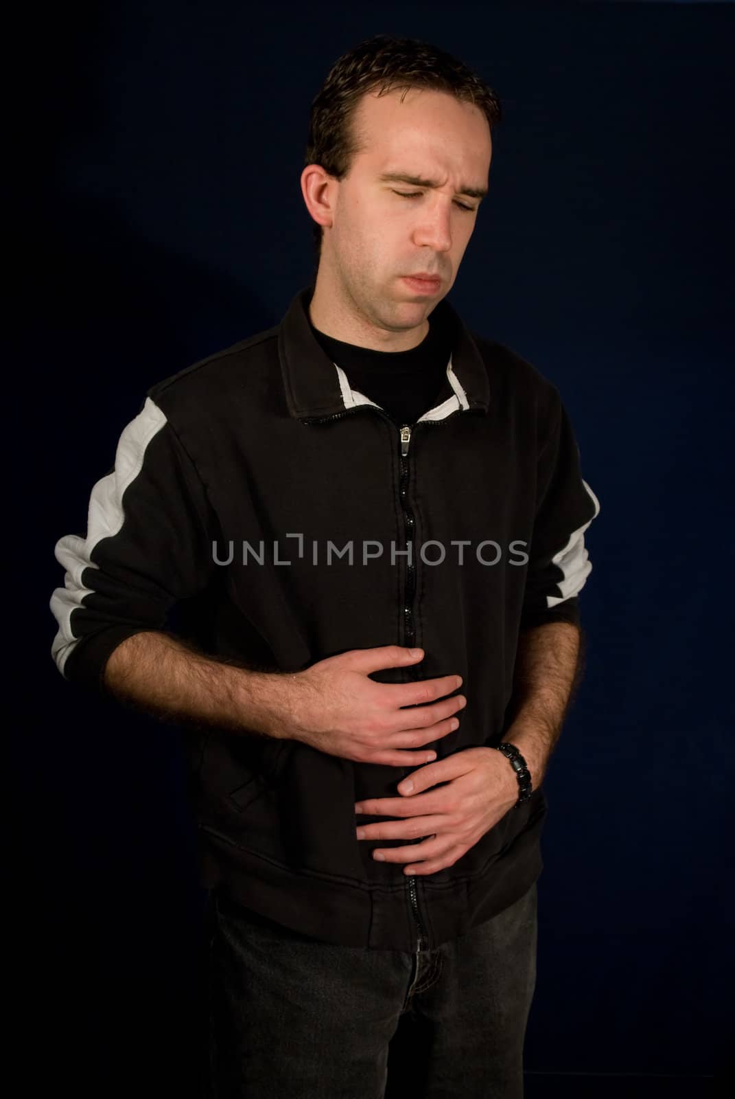Young male holding his belly because he has an upset stomach