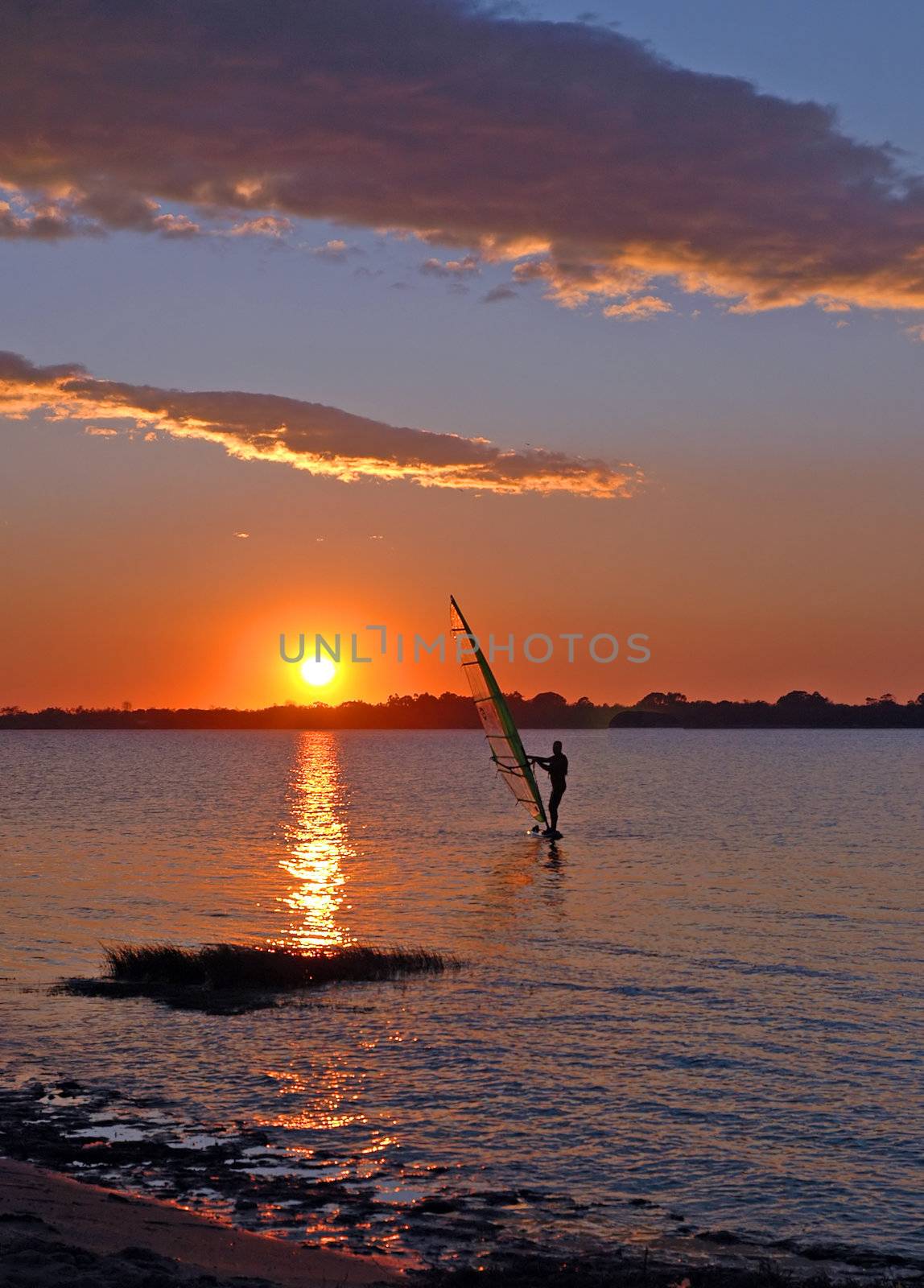  windsurfer speeding fast against the sunset