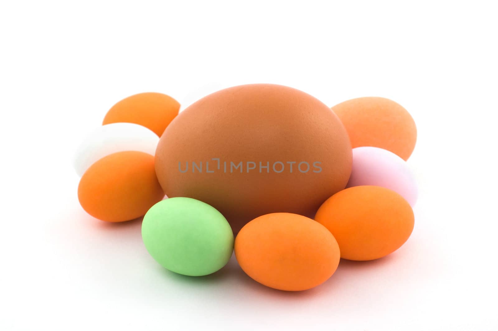 Egg surrounded by little colored Easter eggs on white background