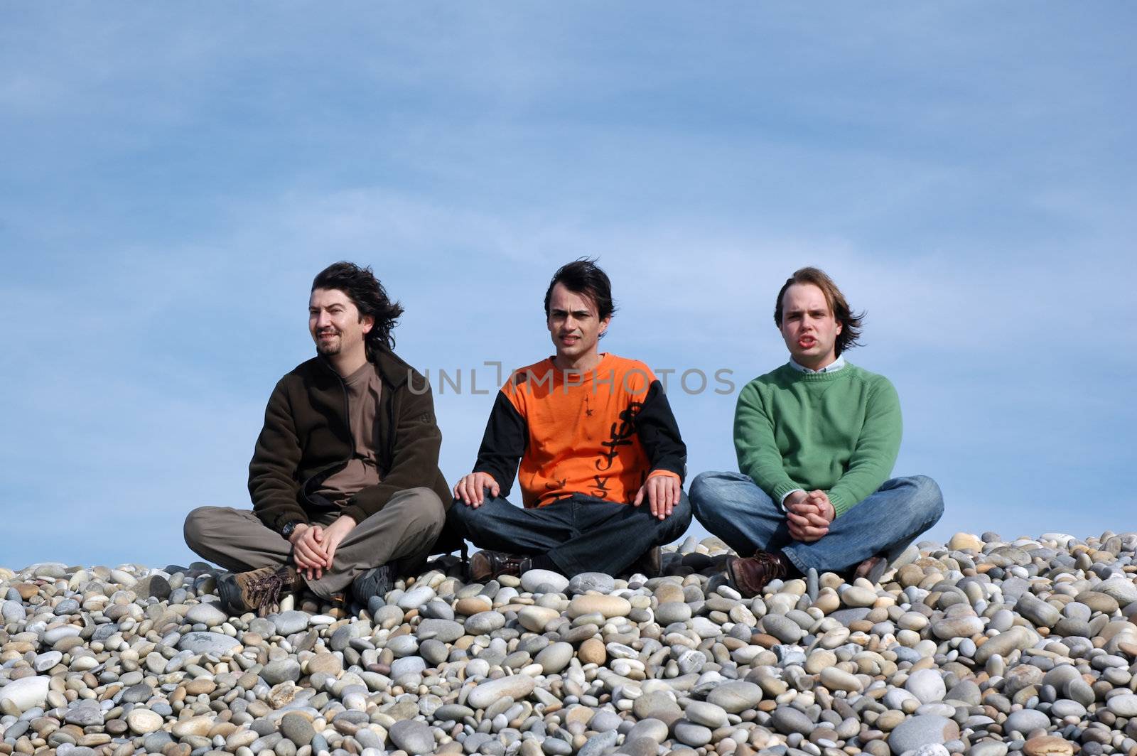 three maens with casual clothes on beach