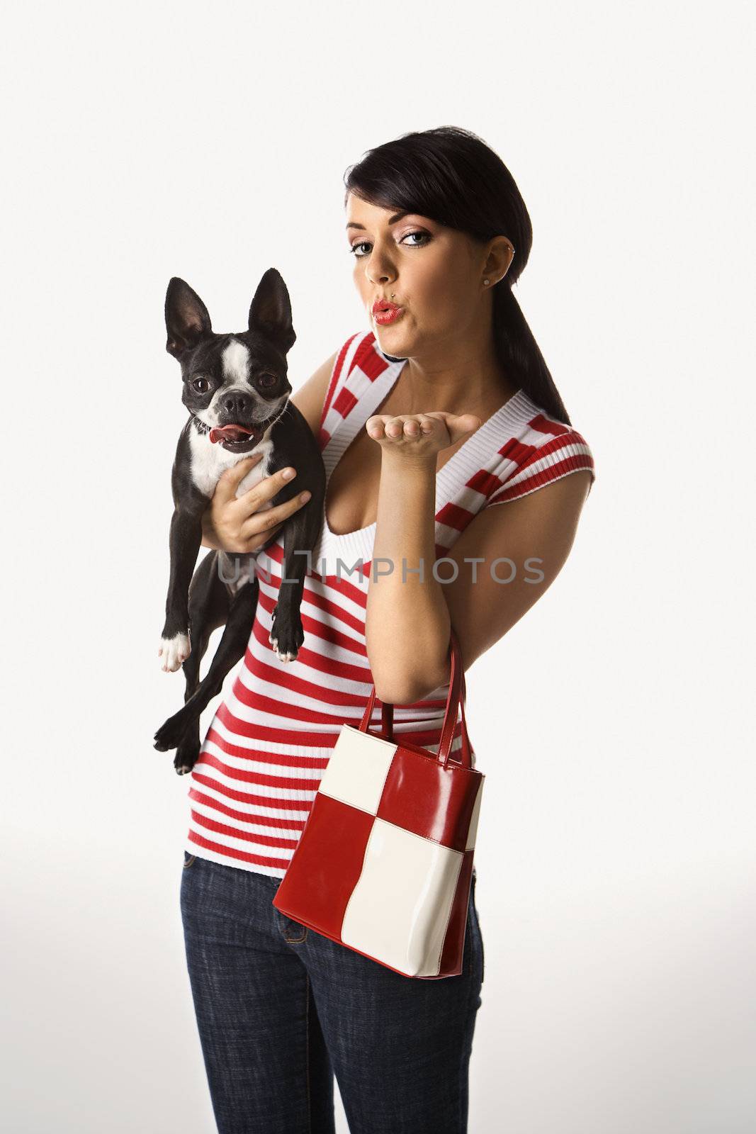 Young adult female Caucasian holding Boston Terrier.