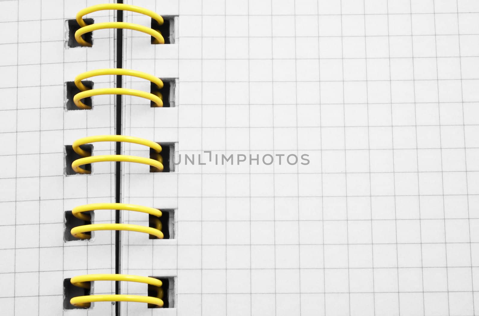 Close up of a spiral bound notebook with yellow spirals