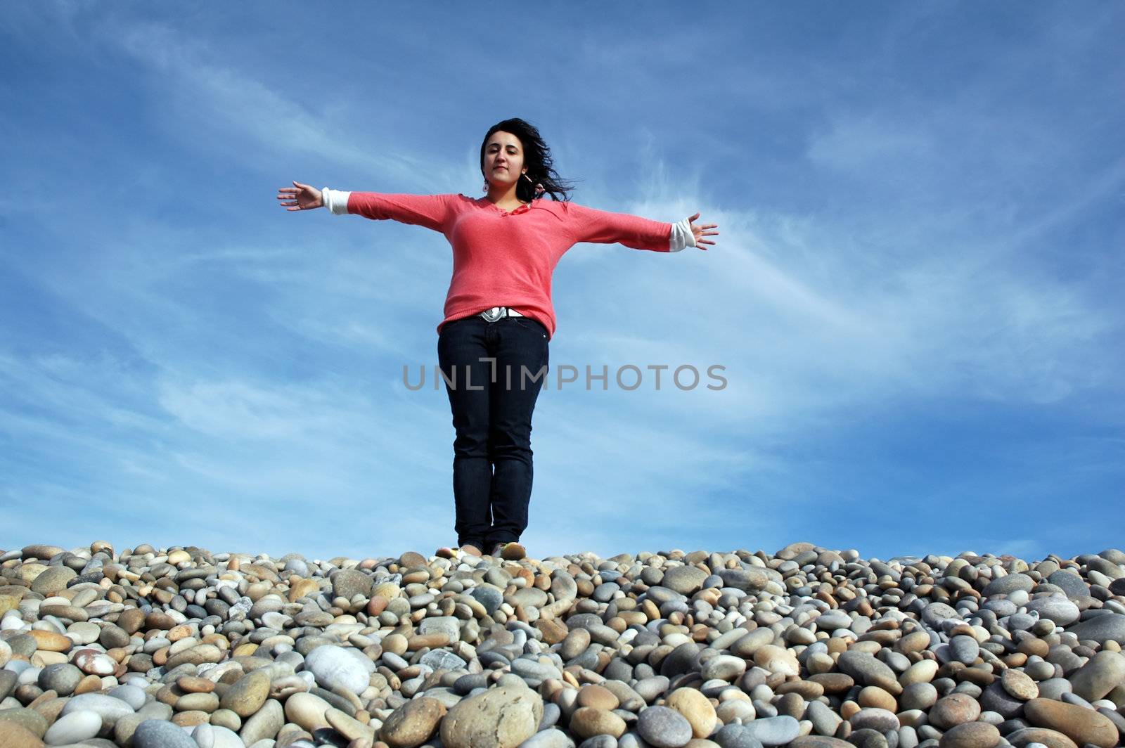 happy woman with arms wide open at the coast by raalves