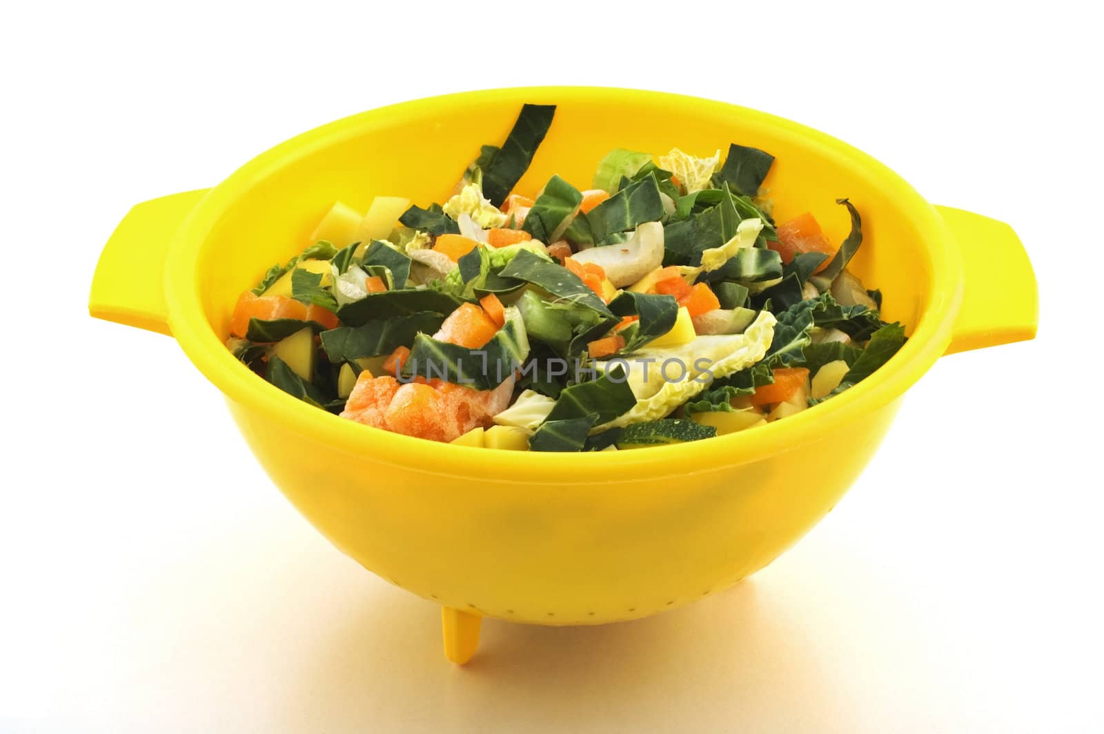 Chopped vegetables in yellow plastic bowl isolated on white