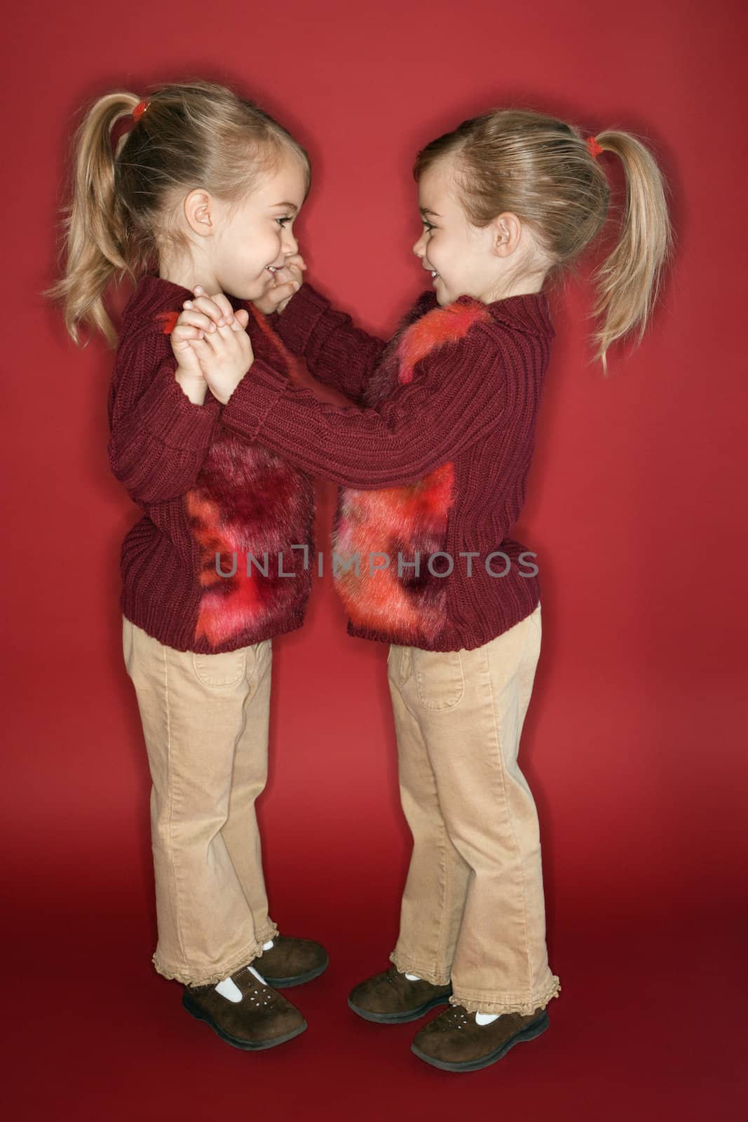 Female children Caucasian twins standing in dance stance.
