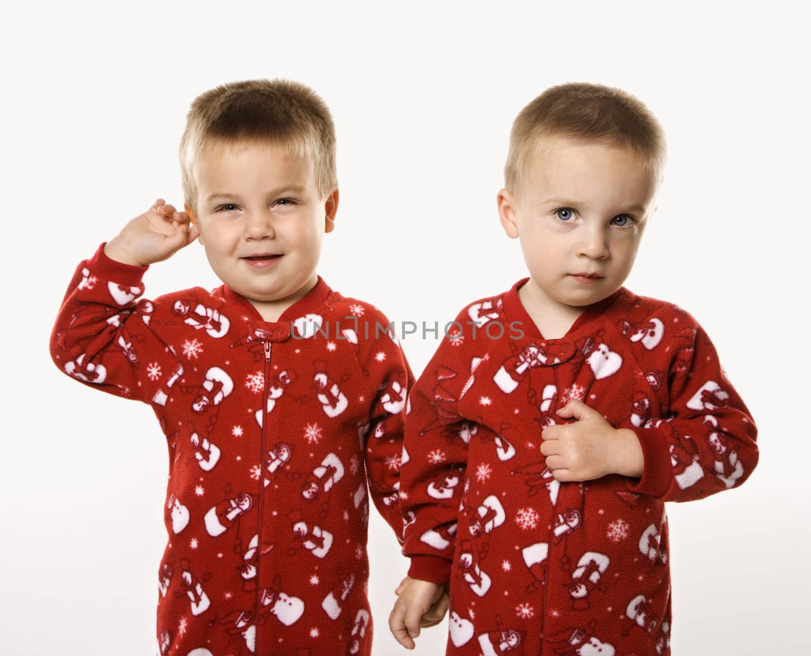 Caucasian male twin children holding hands.