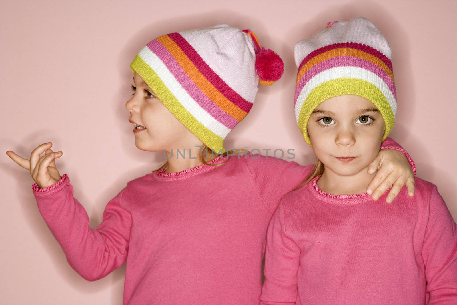 Young female twin Caucasian children standing together.