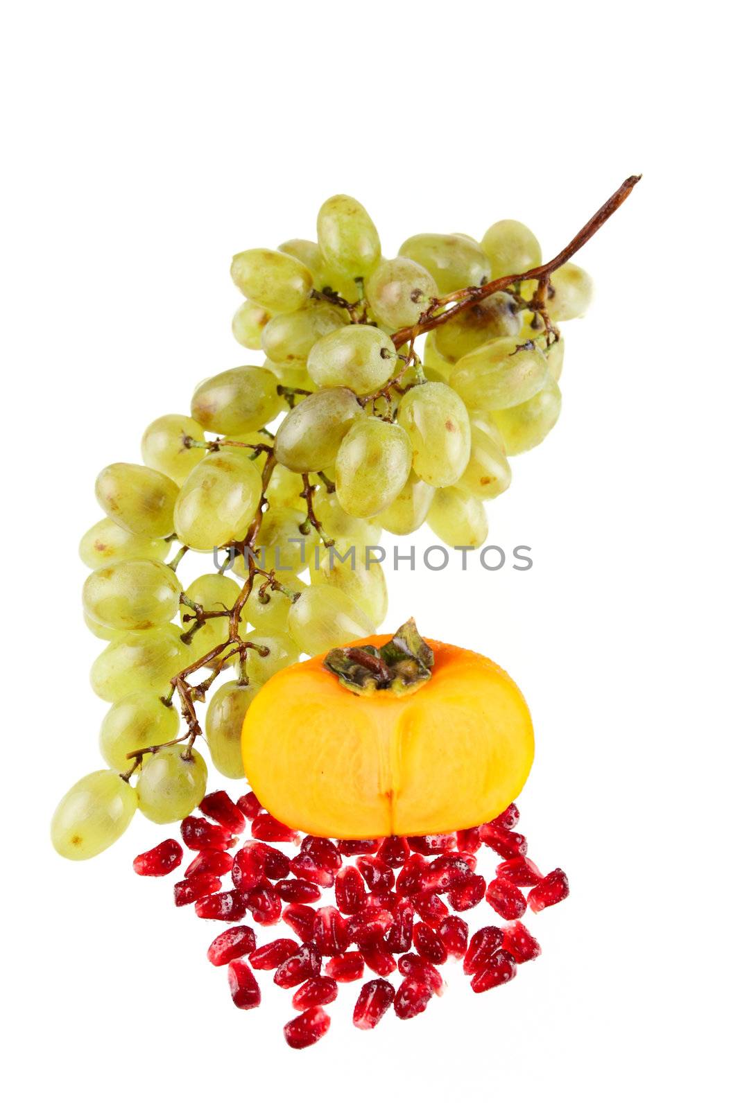 Grapes, a pomegranate and a persimmon removed close up on a white background without isolation