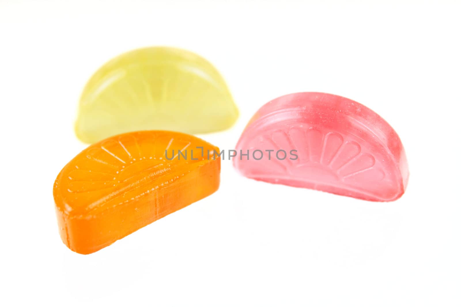 Red and yellow sugar candy removed on a white background close up