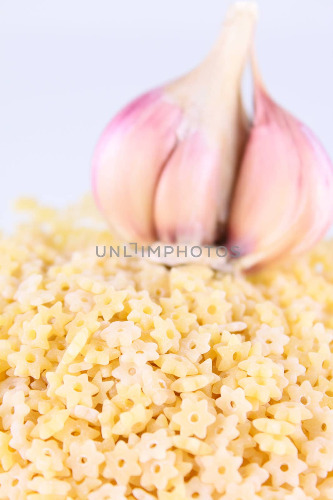 Asterisk pasta removed close up against garlic without isolation