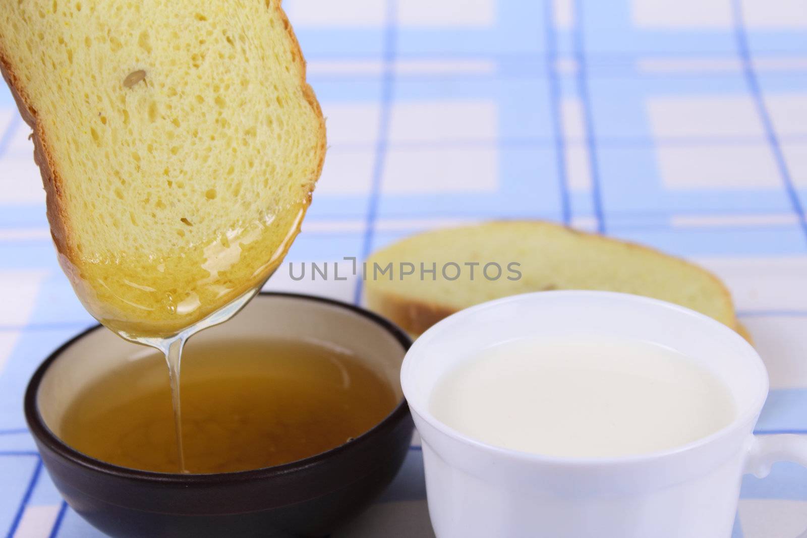 Cornbread with honey and milk on a linen blue napkin removed close up