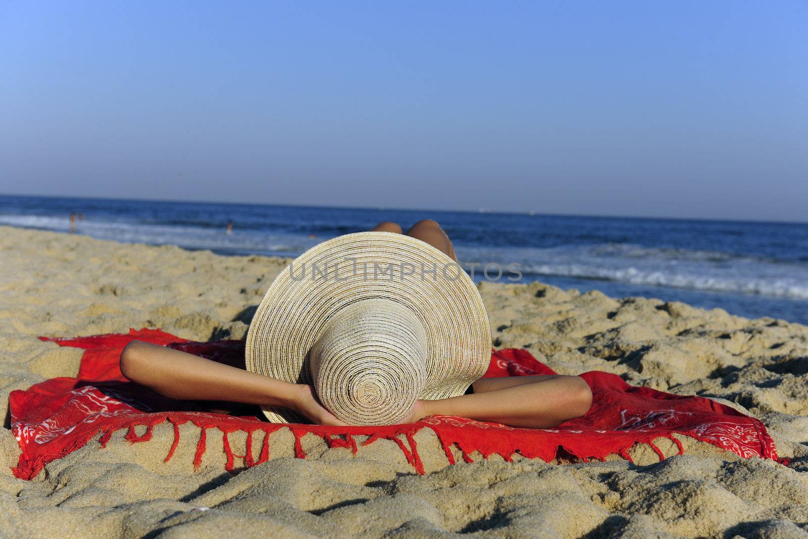 woman lying on the beach relaxing and enjoying the sun by mangostock