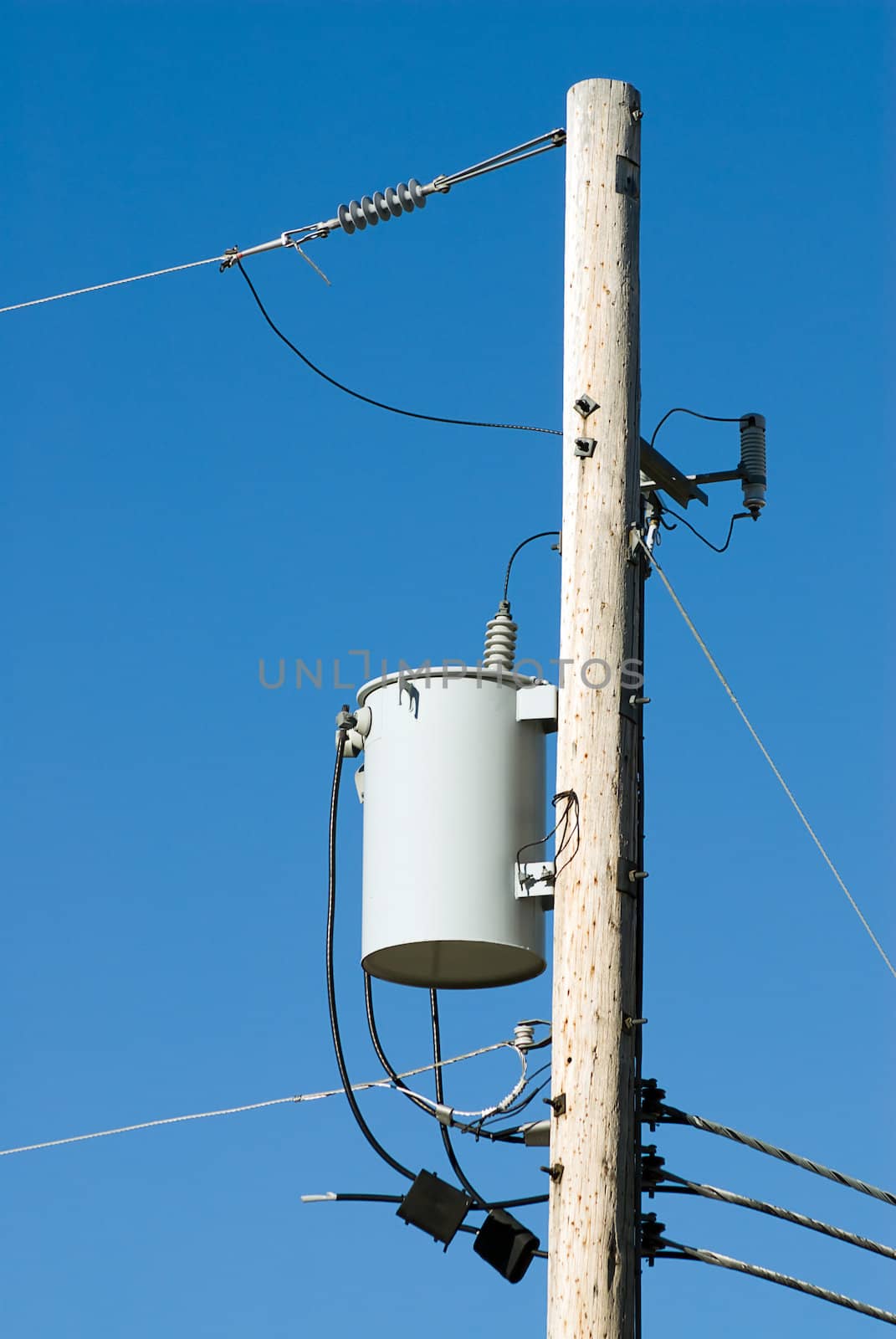 Close-up view of the top of a power line pole with transformer