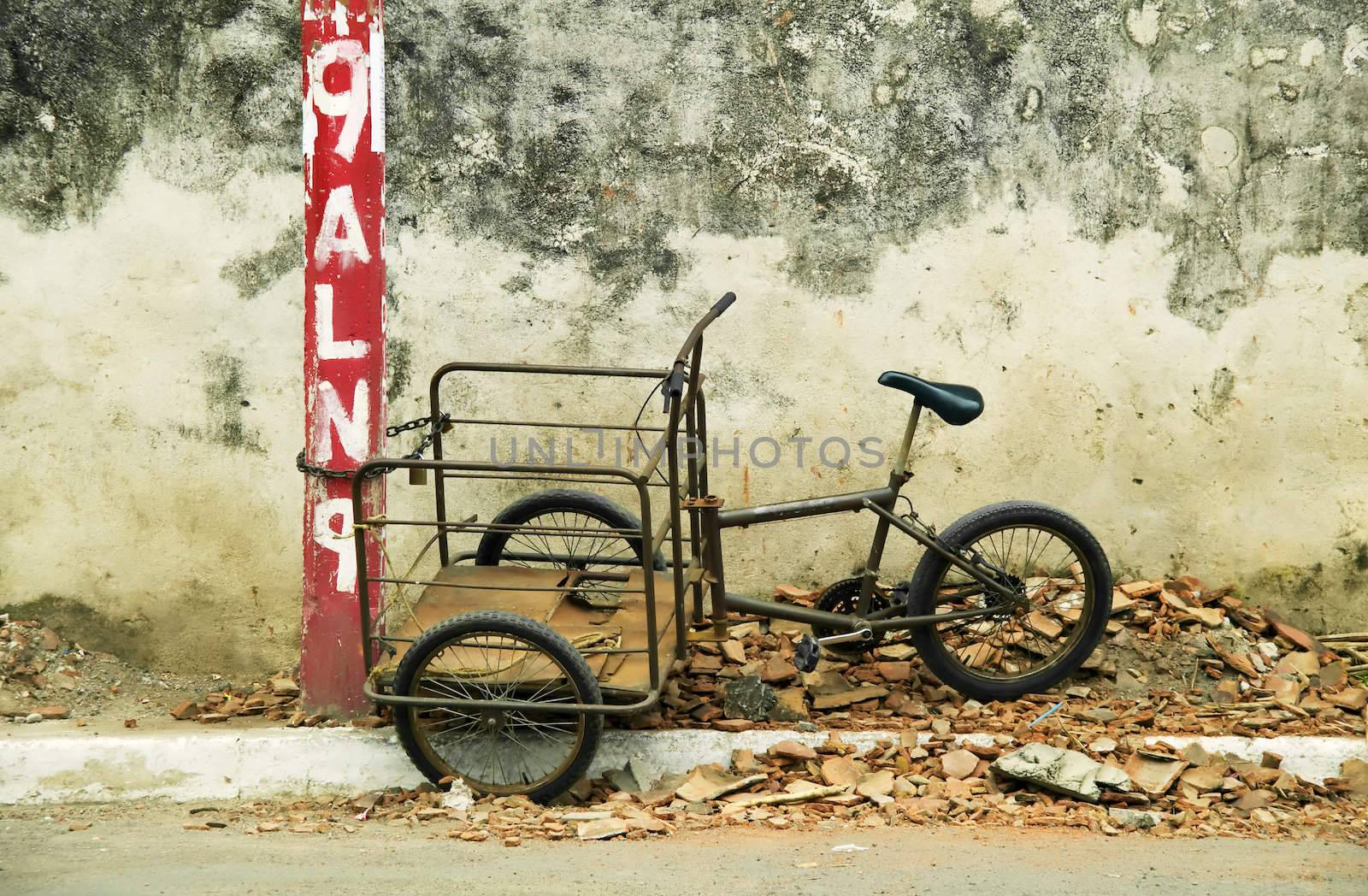 Tricycle chained to a red post roadside in Granada Nicaragua