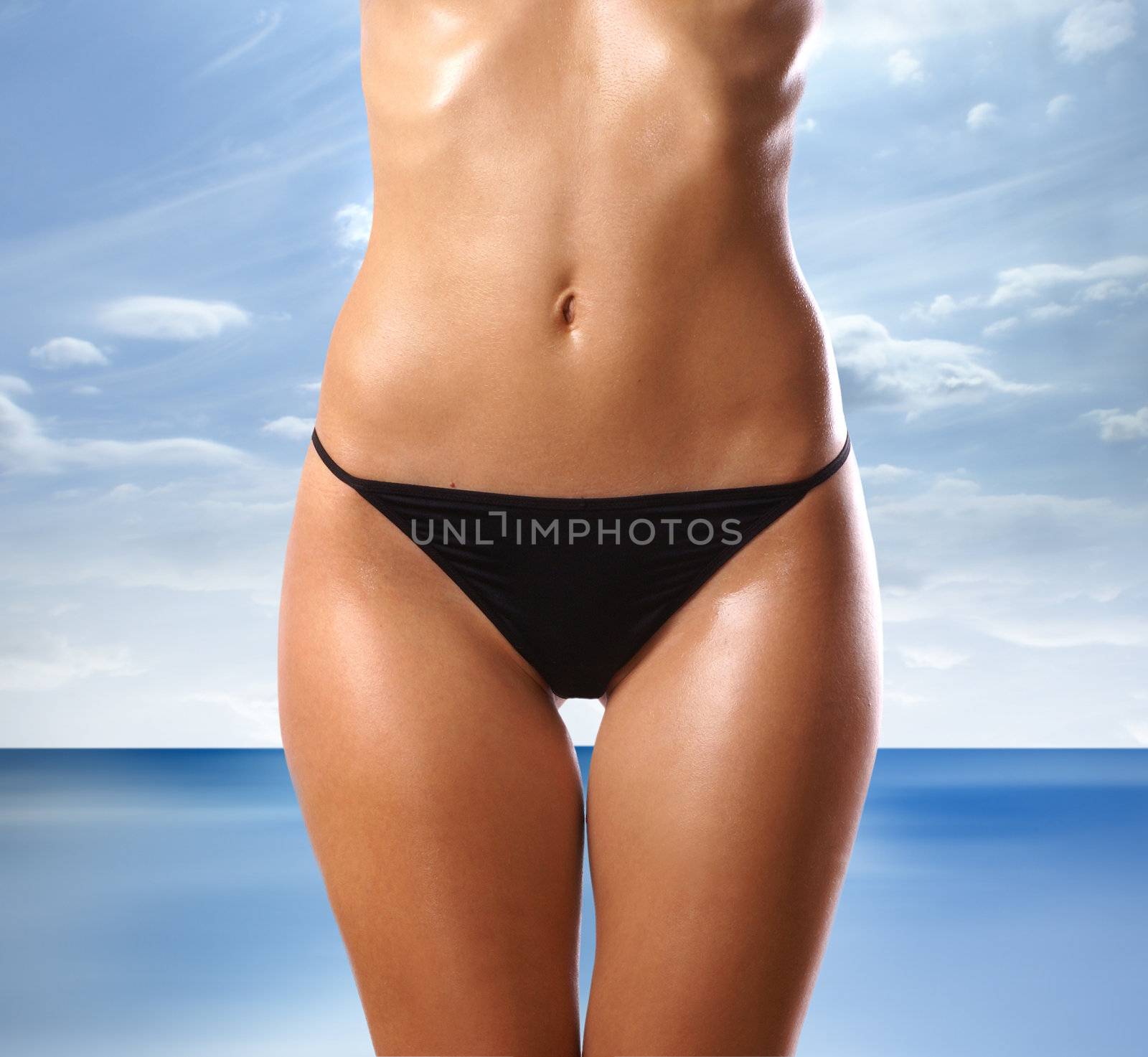 Belly of beautiful woman over abstract resort background