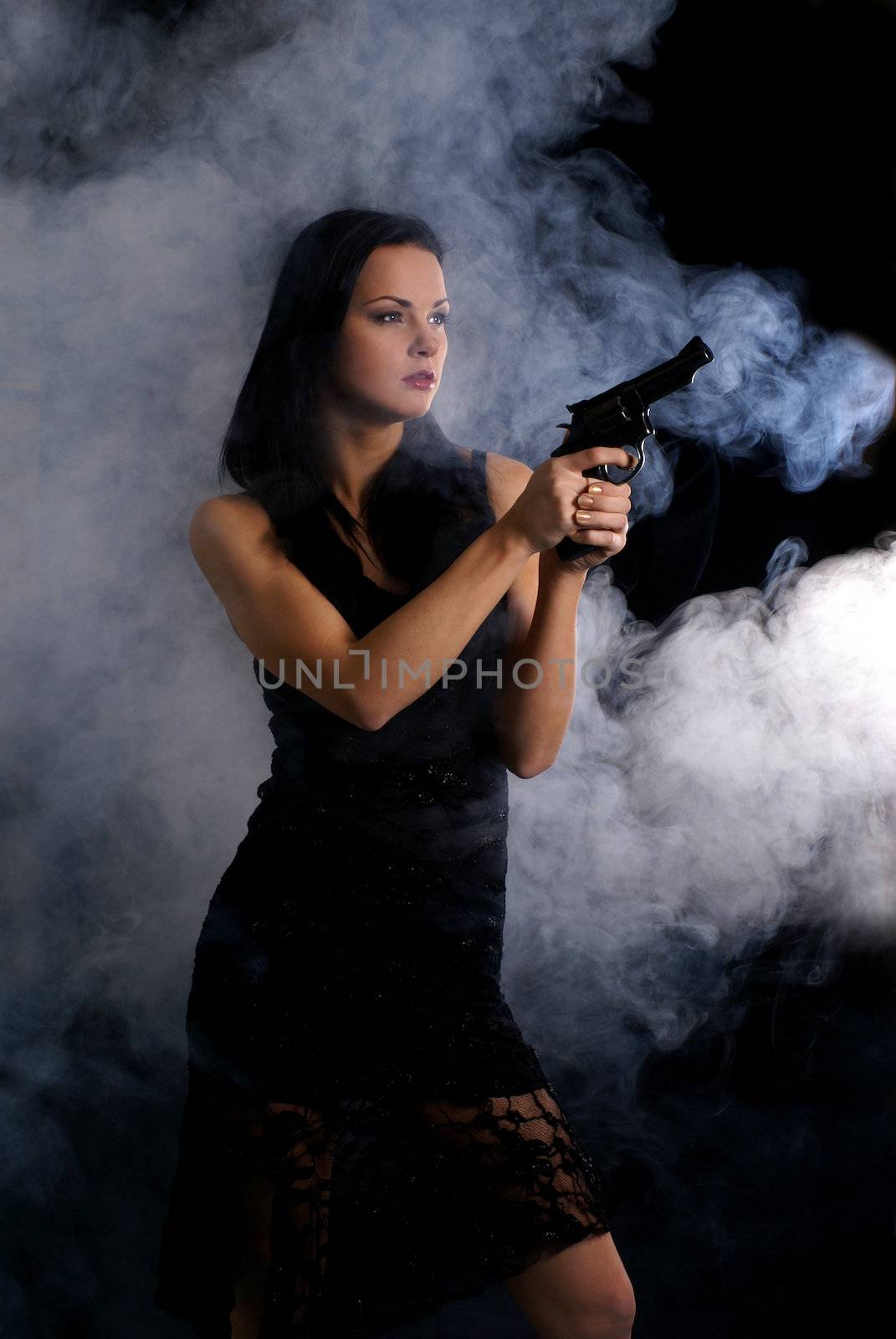 Sexy woman with weapon on smoky background