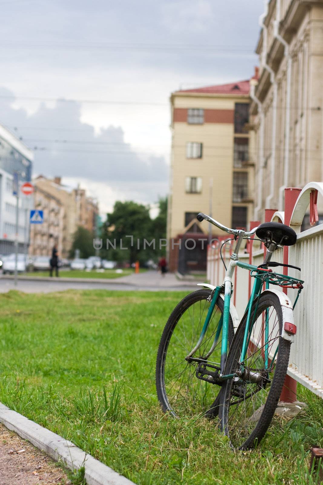 old-fashioned russian bike stand close to metal fence