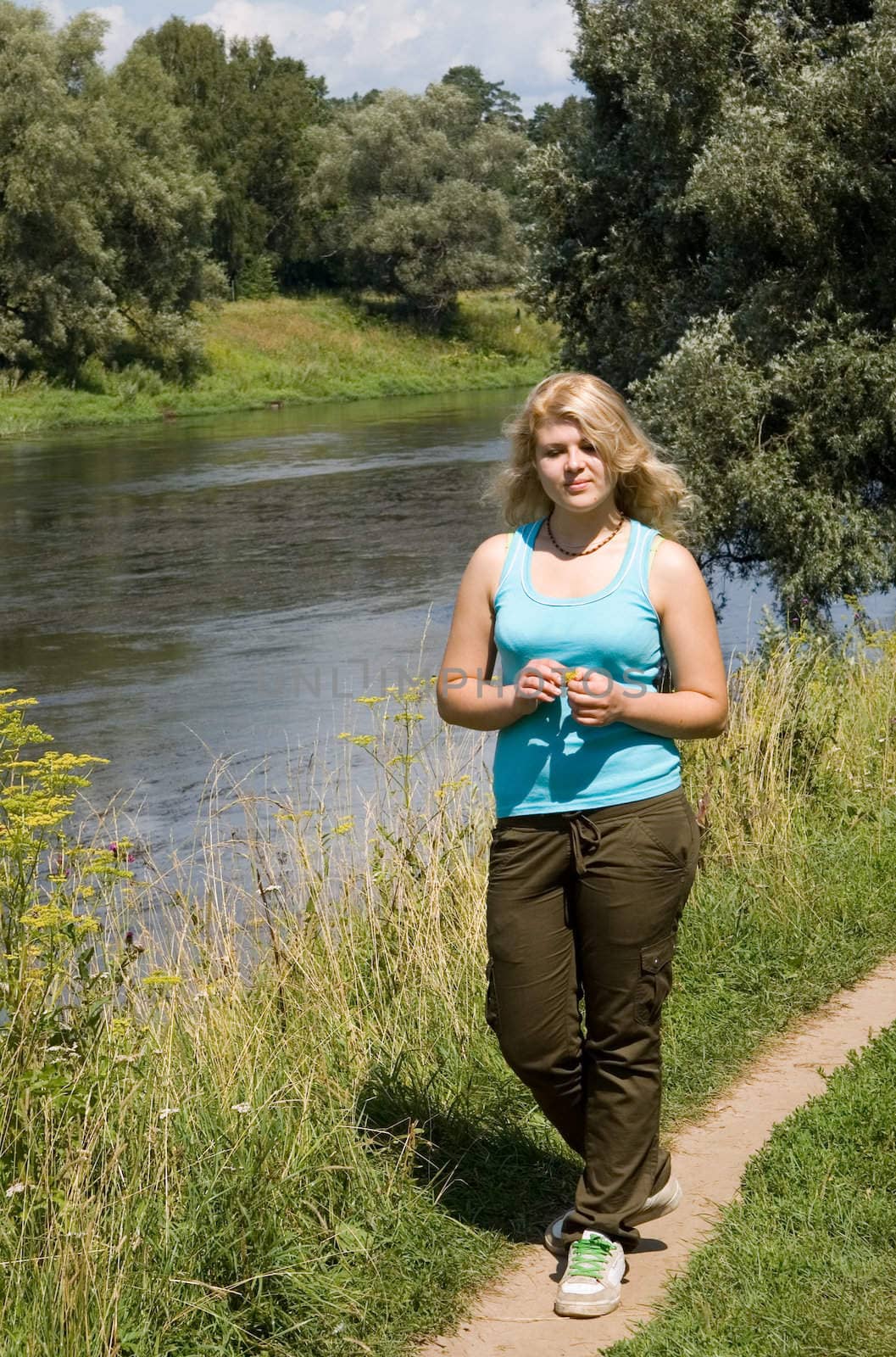 Young beautiful woman near the river