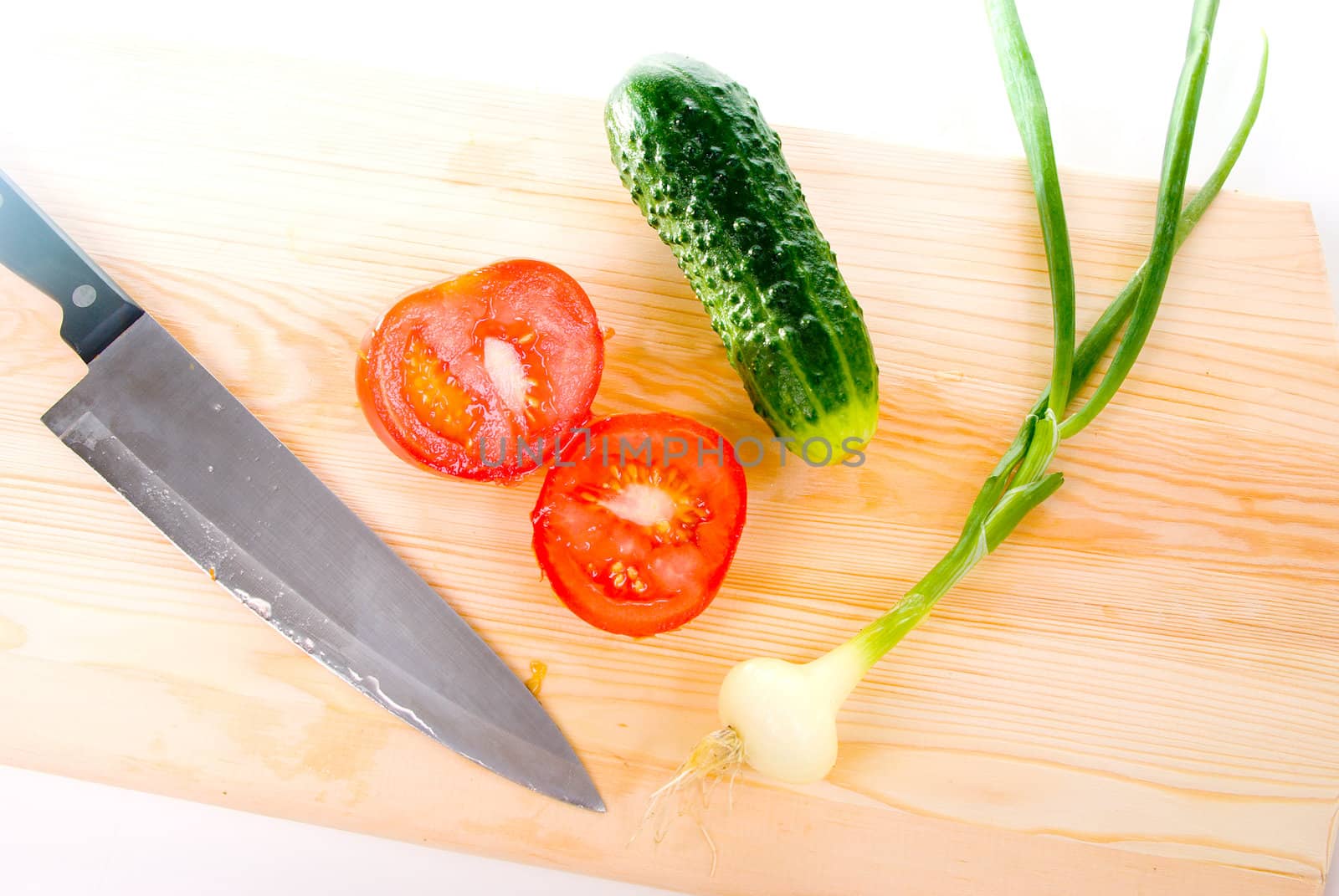 The Knife and fresh vegetables.Tomato,cucumber and onion