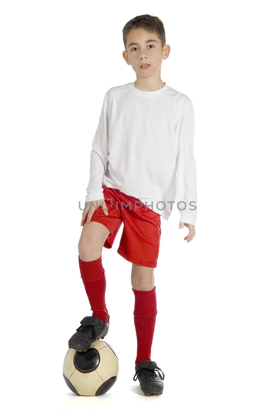 a boy in football uniform with his foot on a football