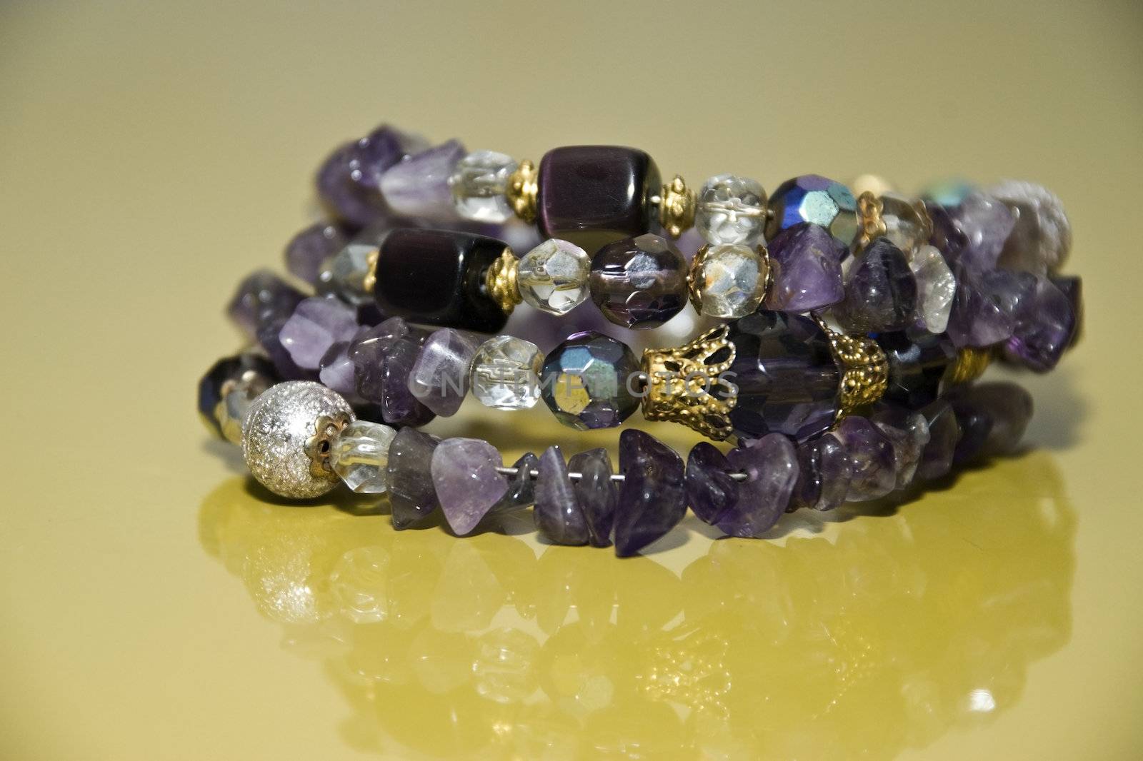 Bracelet with amethyst isolated on a yellow background