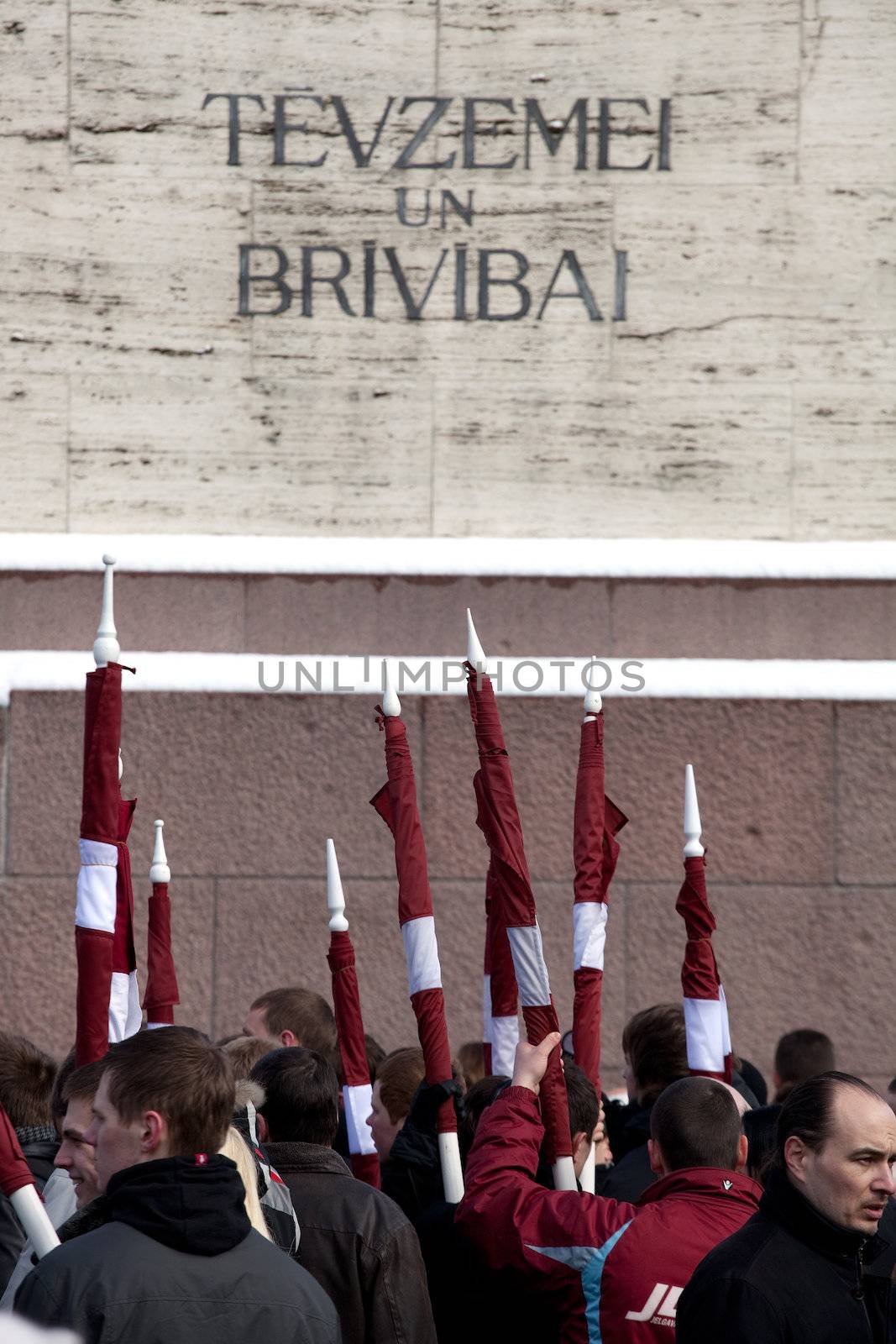RIGA, LATVIA, MARCH 16, 2010: Latvian flags at Freedom monument. Commemoration of the Latvian Waffen SS unit or Legionnaires.The event is always drawing crowds of nationalist supporters and anti-fascist demonstrators. Many Latvians were forcibly called to join the Latvian SS Legion.