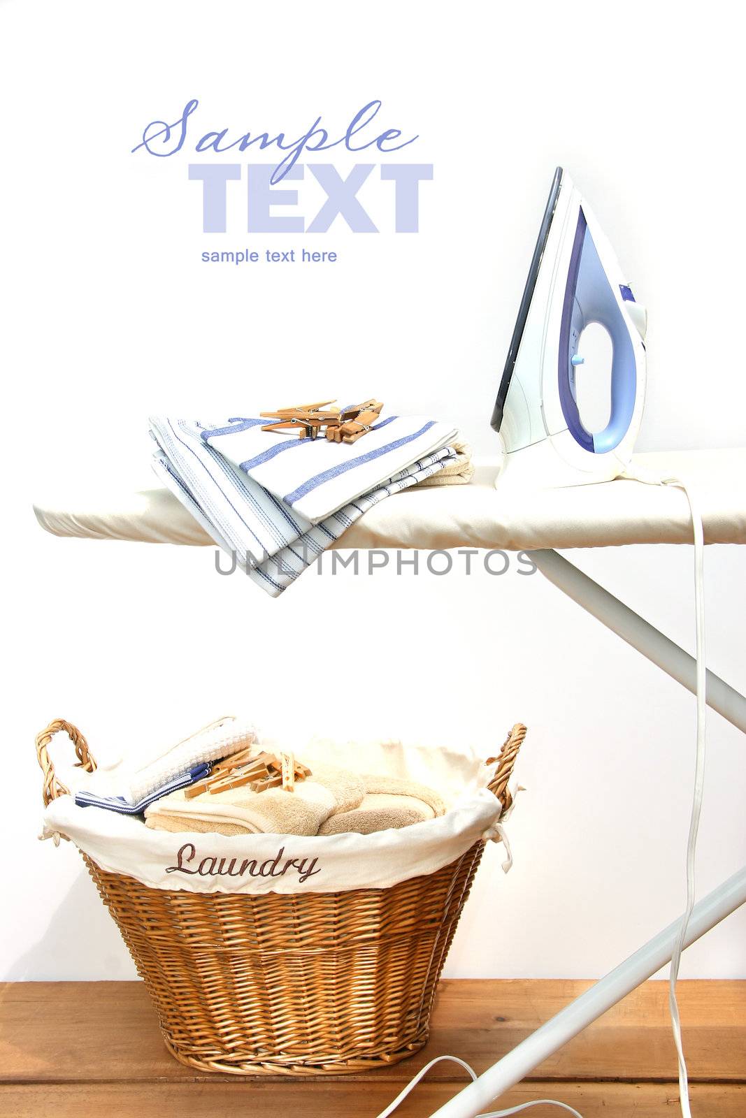 Ironing board with laundry against white background