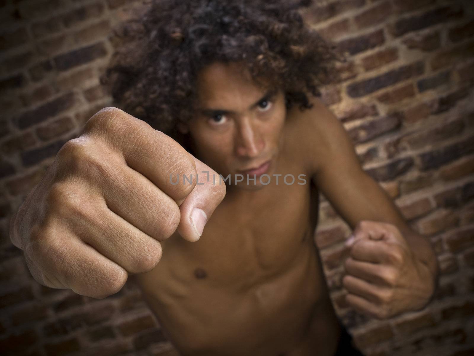 A young man throwing his fist to the camera. Focus on the hand.