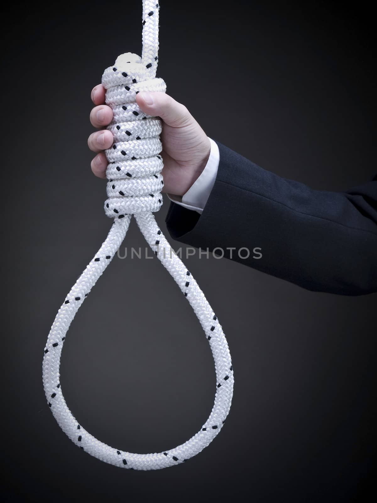 A man on a suit holds a hangman's noose over a gray background.