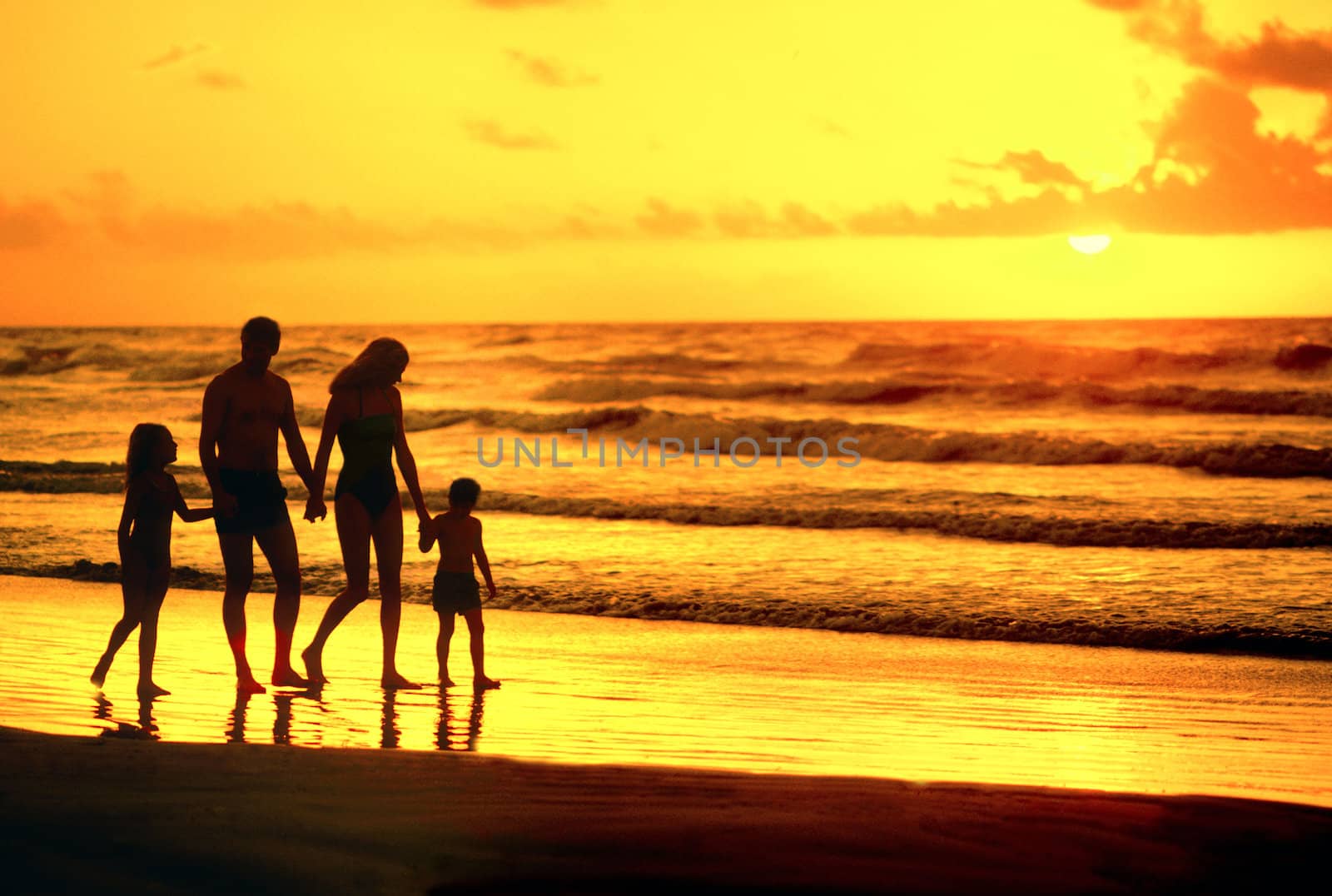 family walking on beach silhouette