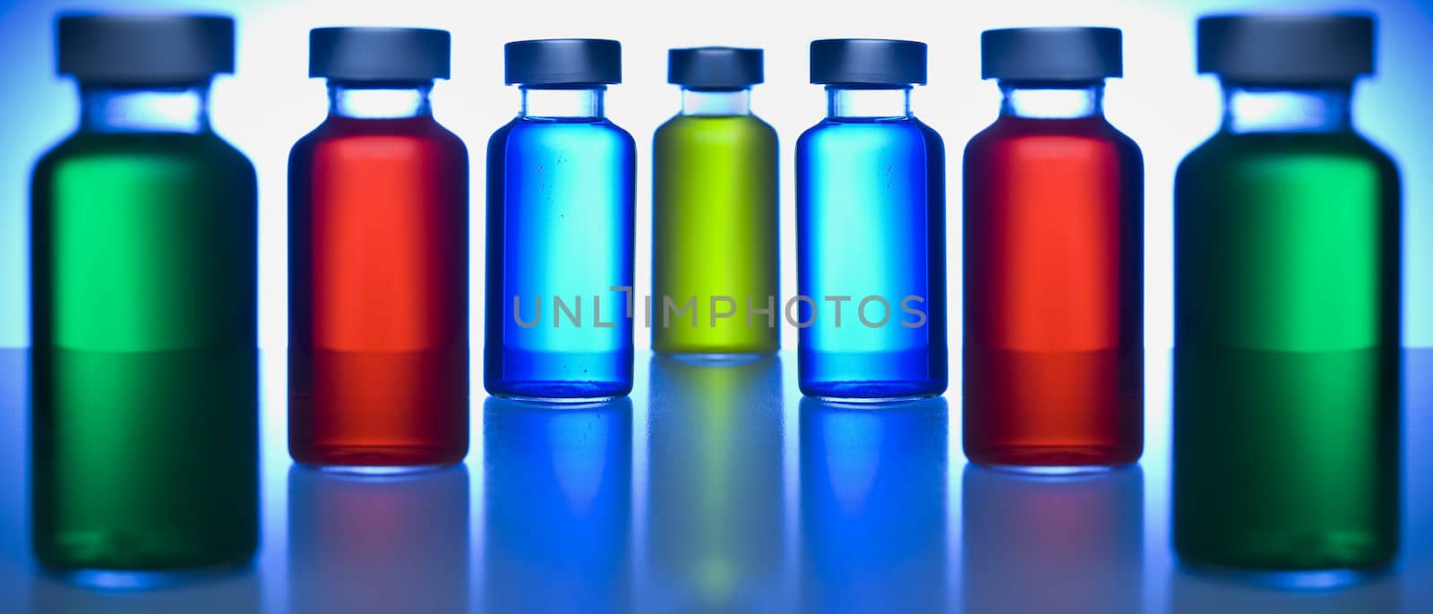 Two rows of vials filled with colored liquids. Focus on the blue ones.