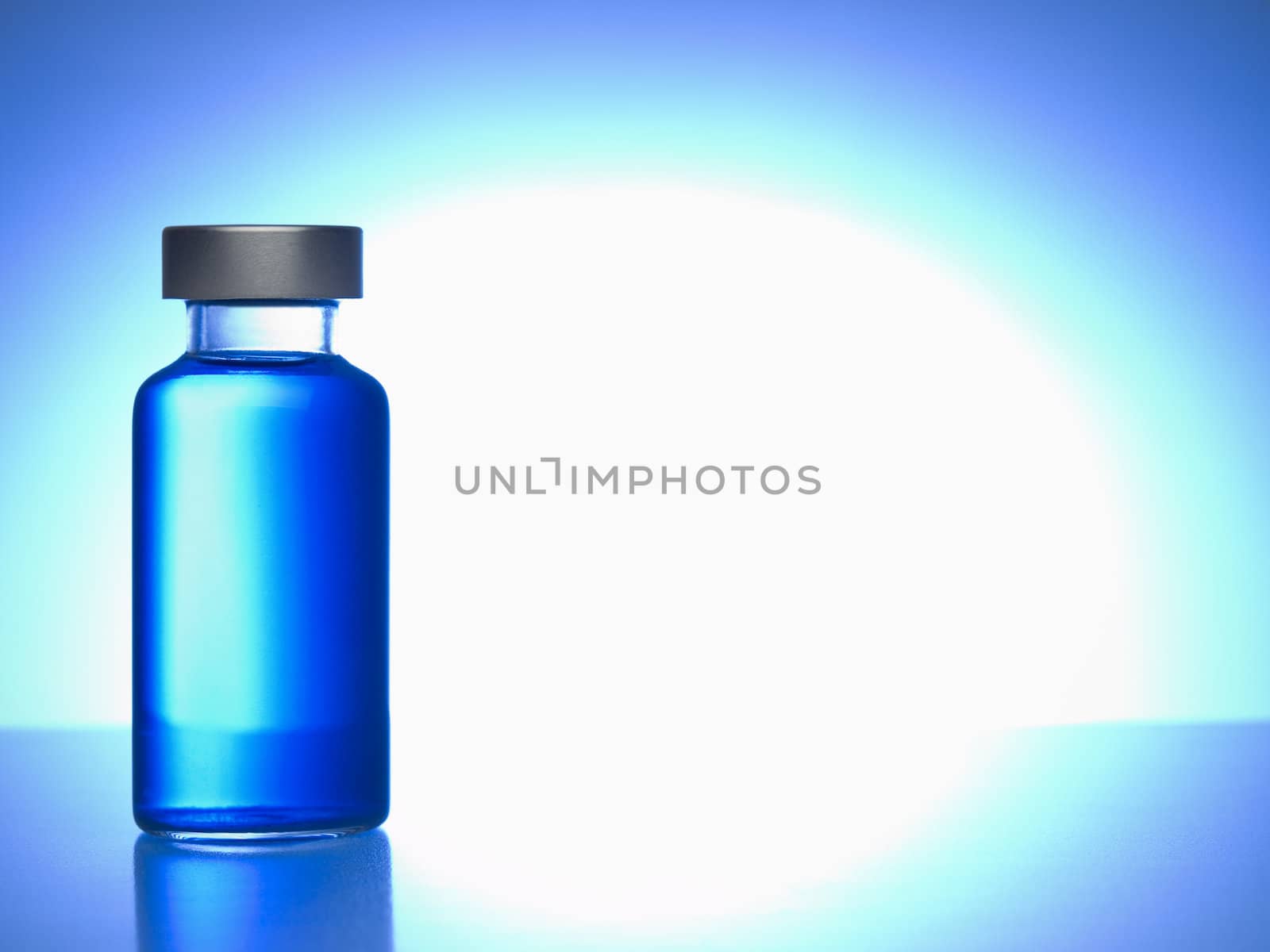 Close up of a vial filled with blue liquid. Copy space.