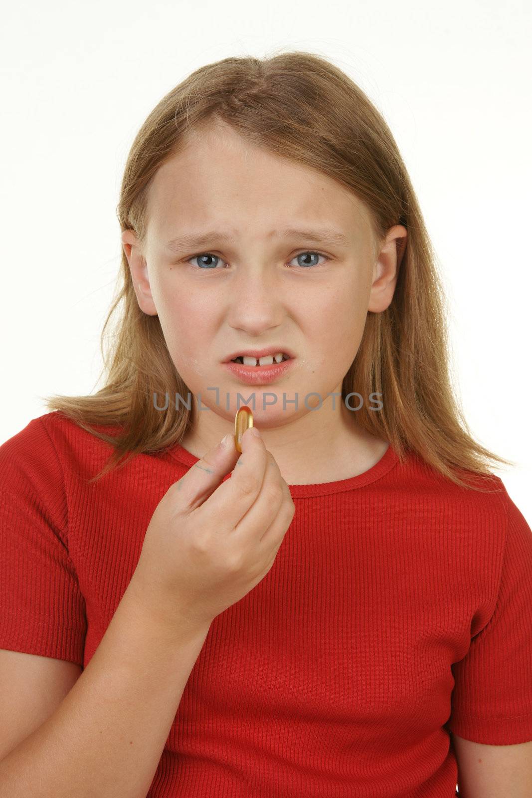 young girl not happy about taking a pill