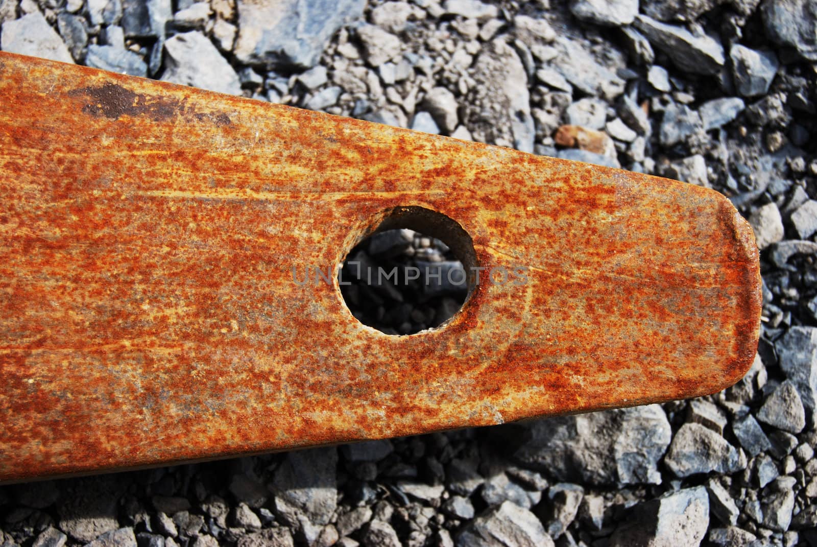 closeup of a rusty metal piece on grey pebbles