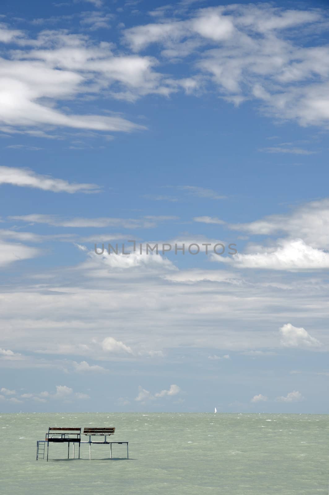 Fishing pier against blue sky with clouds