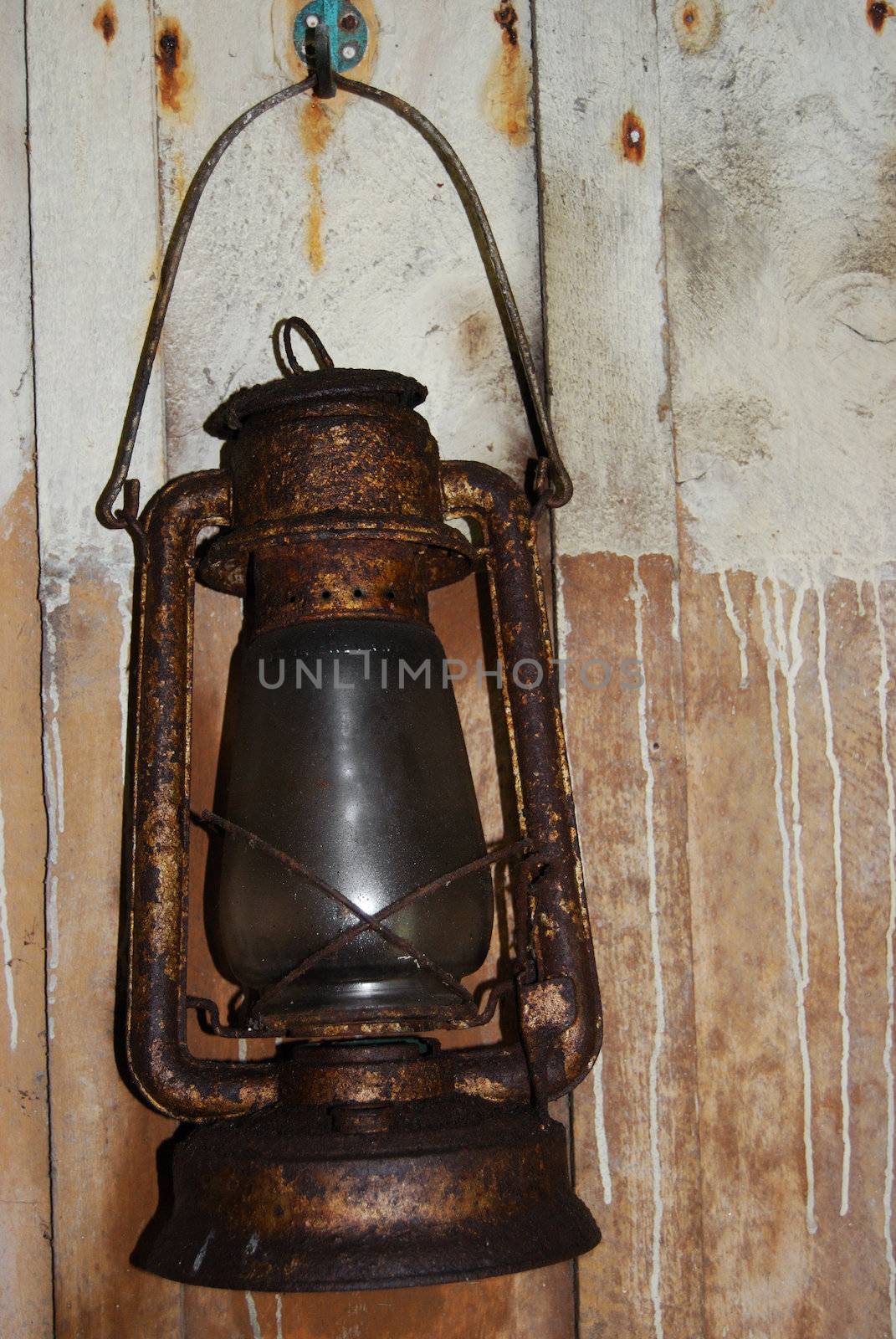 old petrol lamp hanging on a wooden wall
