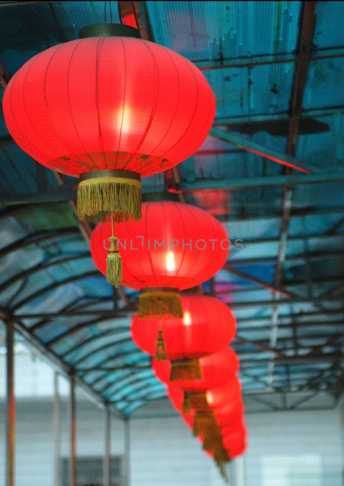 Red lantern, shining, typical Chinese decorations for new year. Hanged under the blue roof.