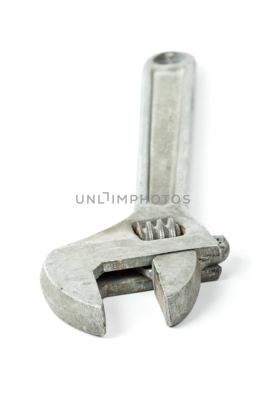 Old adjustable spanner isolated on white background - shallow depth of field