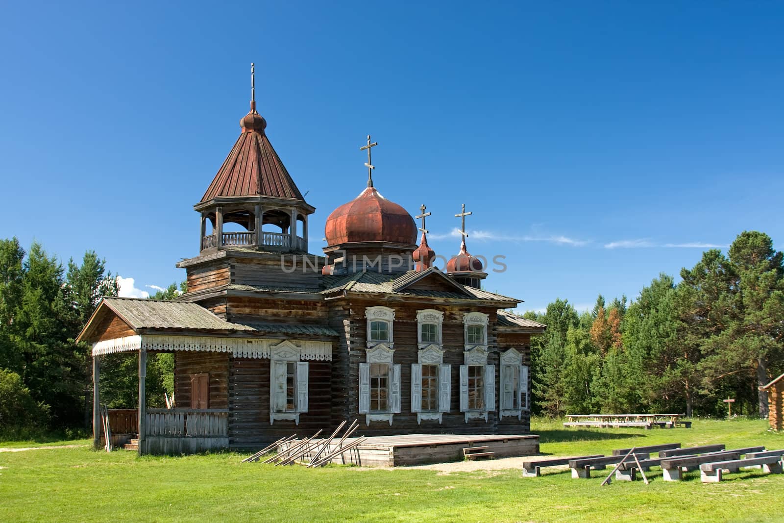 Antique old russian wooden church in the green forest