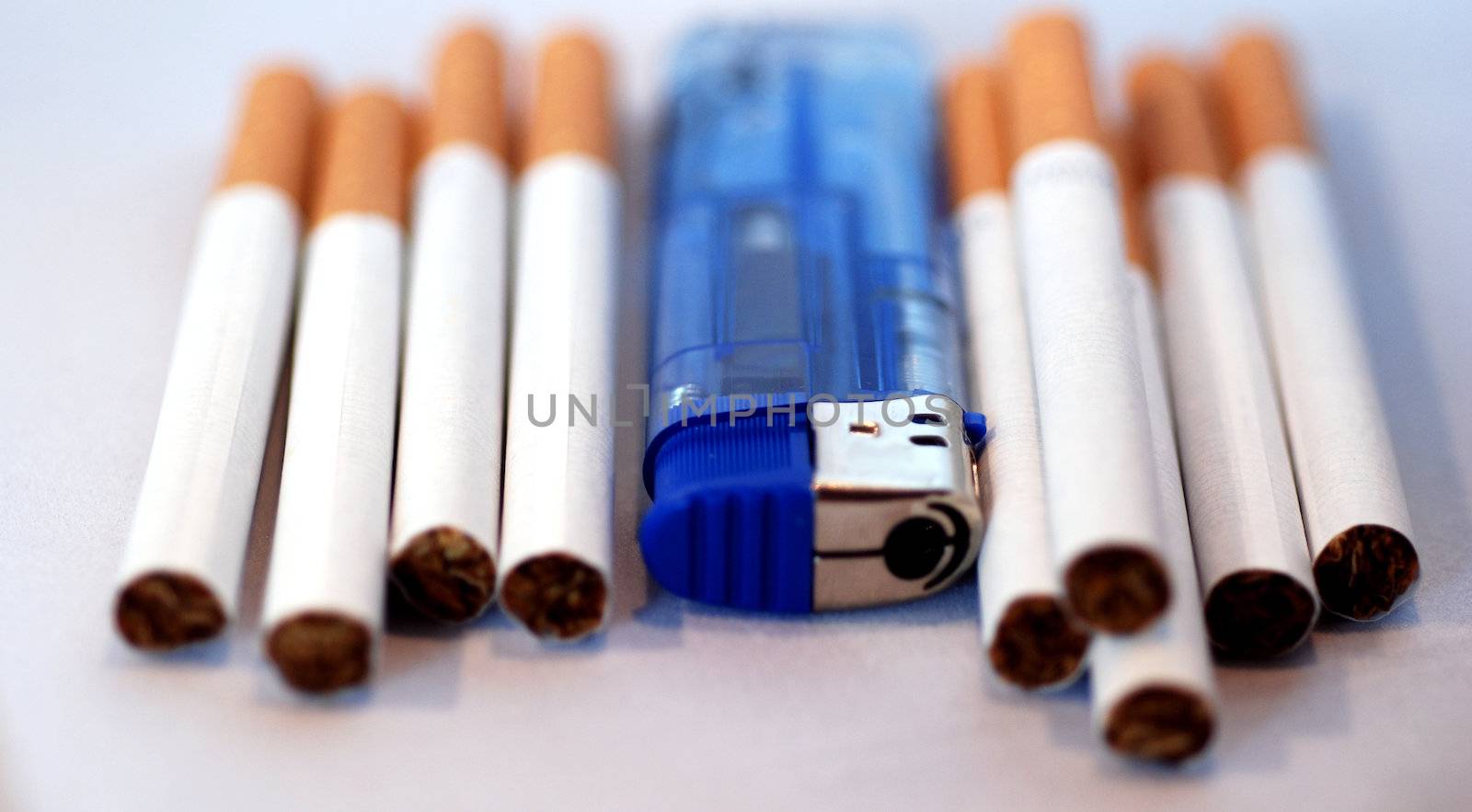 A close up photograph of cigarettes and a blue lighter