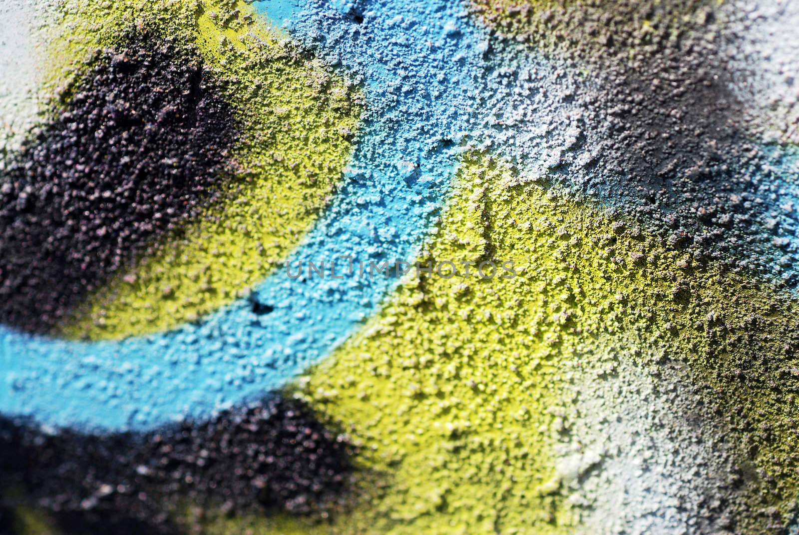 A close up photograph of spray painted graffiti on a textured concrete wall