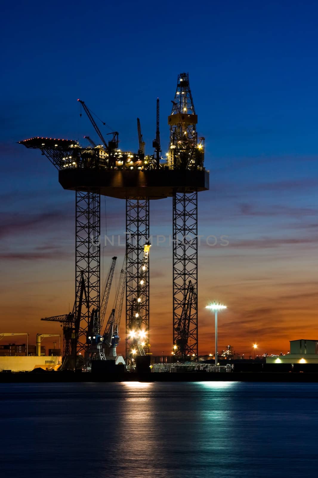 Big drilling platform in repair in the harbour at sunset