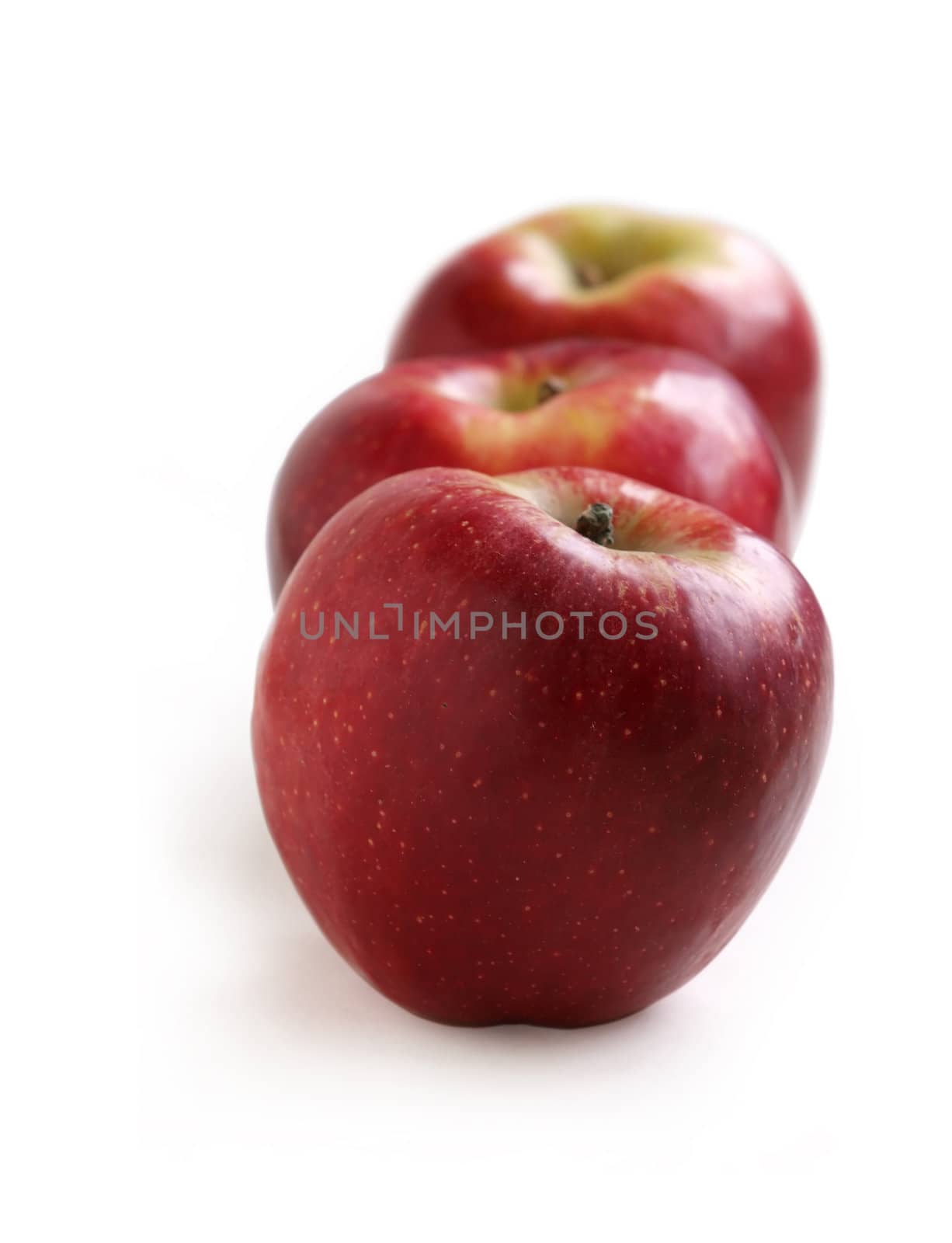 Row of red apples on a white background 
