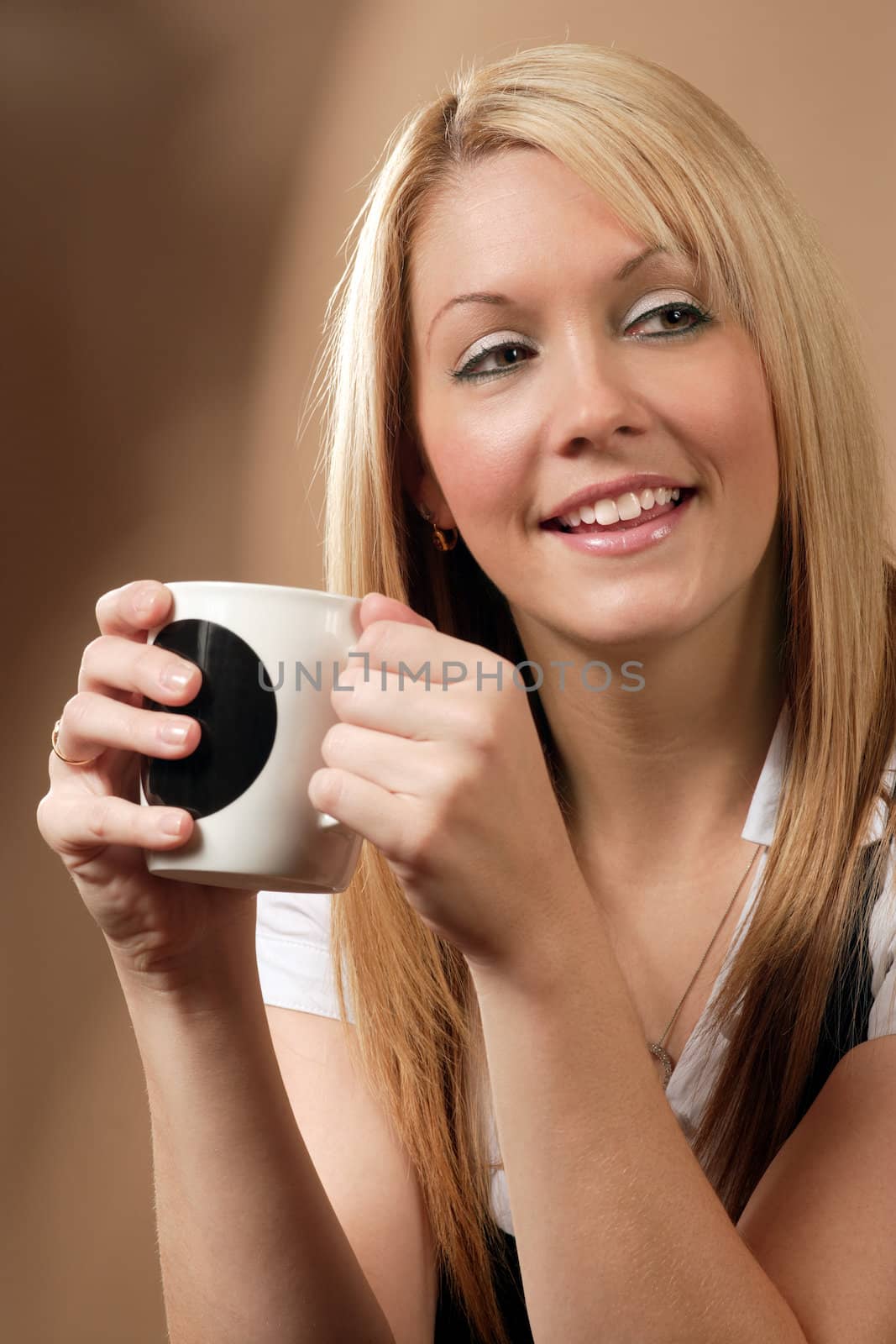 Happy and smiling female drinking coffee in an urban café.
