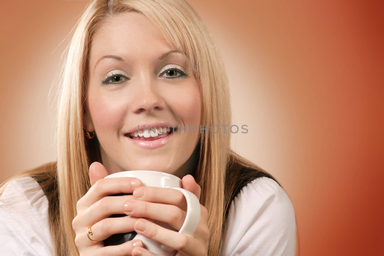 Happy and smiling female drinking coffee in an urban café.
